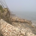 Argine costruito in zona Pai, pietre e terra corrose dal mare.