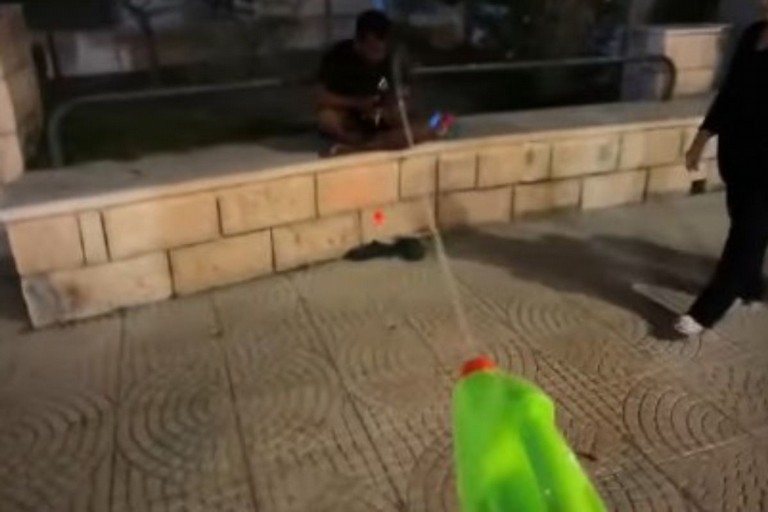 Spruzza acqua ai passanti in strada a Margherita di Savoia
